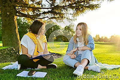 Female teacher psychologist social worker talking to teenage student on the lawn Stock Photo