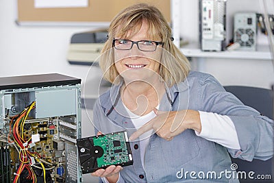 female technician pointing at repaired computer Stock Photo