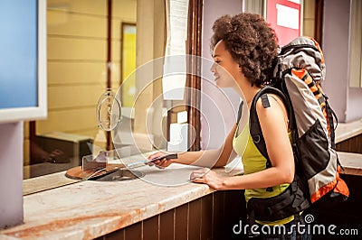 Female tourist buys a ticket at terminal station ticket counter Stock Photo