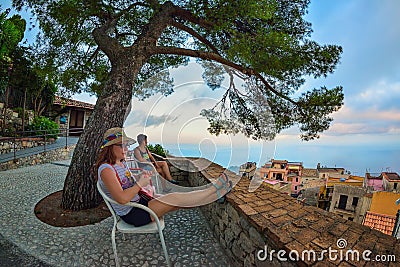 Female tourist enjoying Taormina view at sunset Stock Photo