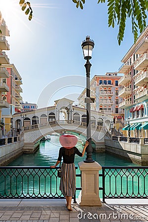 Female tourist enjoys the view to the Qanat Quartier on the Pearl in Doha Stock Photo