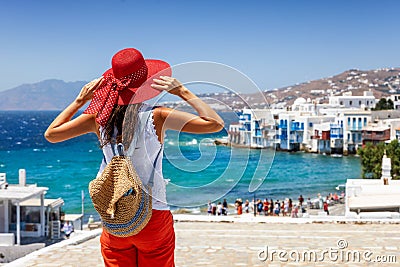 Female tourist enjoys the view to the town of Mykonos island, Greece Stock Photo