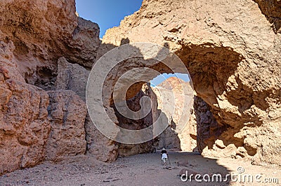 Female tourist hiking under Natural bridge, Death Valley NP Stock Photo