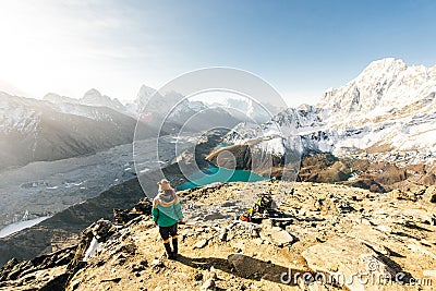 Female Tourist Hikking at gokyo ri mountain peak near gokyo lake during Everest base camp trekking in nepal Stock Photo