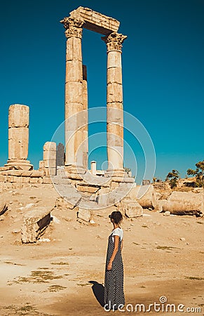 Female tourist in long sundress visit and exploring historic attraction. Woman enjoy summer vacation. Sightseeing tour. Tourism in Stock Photo