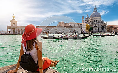 Female tourist looking the Basilica di Santa Maria della Salute and Canale Grande in Venice, Italy Stock Photo