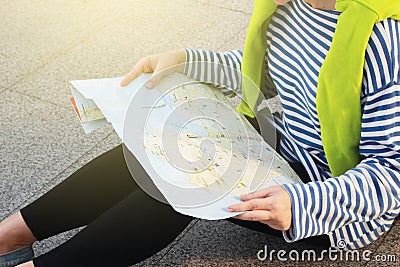 Female tourist with suitcase luggage view map for travel on different city in winter , lost alone concept Stock Photo