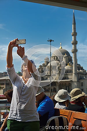 Female tourist taking selfie photo on a cruise boat in Istanbul Editorial Stock Photo