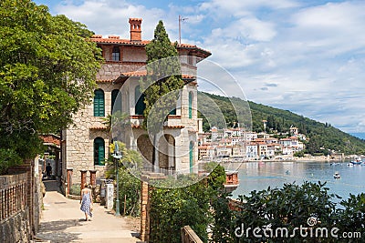 Female tourist walking along Adriatic sea coast relaxing on vacation in Moscenicka Draga, Istria, Croatia. Stock Photo