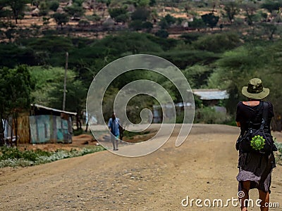 Female tourist walking on the dirt road at the Turmi, Omo Valley, Ethiopia Editorial Stock Photo