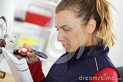 female trainee plumber working on central heating boiler Stock Photo