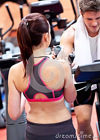 Female trainer with chronometer coaching a man Stock Photo