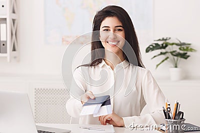 Female travel agent holding passport with tickets Stock Photo