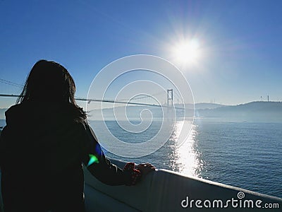 Female traveler looking out at view of Bosphorus bridge, Turkey Editorial Stock Photo