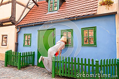 Female traveler looks on the window in Golden Lane, Prague, Czech Republic. Stock Photo