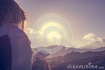 Female traveler writing her thoughts at sunset. Stock Photo