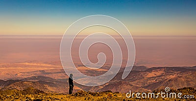 Female trekker enjoys the view from the summit of Jbel Toubkal, Atlas Mountains, Morocco. Stock Photo