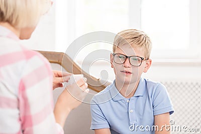 Female tutor asking her pupil to translate word, writed on card. Young boy trying to remeber translation. They are Stock Photo