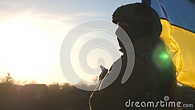 Female ukrainian army soldier using smartphone to read news or messaging with family. Girl in military uniform and Stock Photo