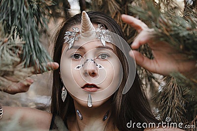 Female unicorn. Fairy girl unicorn walking on the snow in the forest. Stock Photo