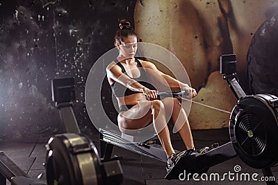 Female using rowing machine in gym. woman doing cardio workout in fitness club. Stock Photo