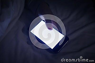 Female using smartphone on her bed Stock Photo