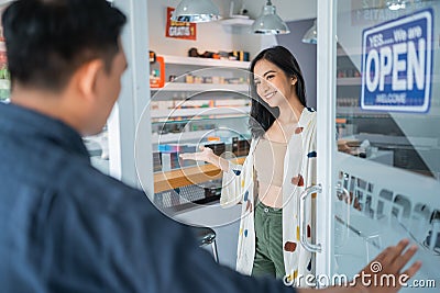 female vape seller welcoming the male customer Stock Photo