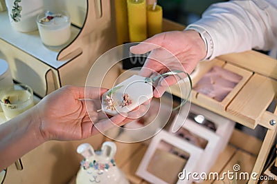 female vendor a marketplace presents a skillfully crafted sachet buyer, displaying artisanship and organic aromas Stock Photo