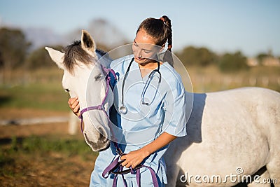 Female vet stroking horse Stock Photo