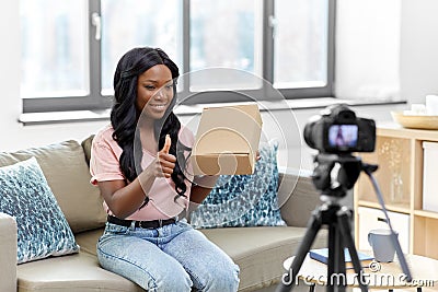 Female video blogger with camera and box at home Stock Photo