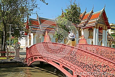 Female Visitor on Beautiful Bending Bridge Crossing a Canal inside Wat Benchamabophit Temple, Bangkok, Thailand Stock Photo