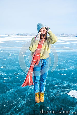 Female wanderer dressed in fashionable hat and mittens and scarf standing outdoors Stock Photo