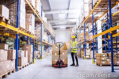 Female warehouse worker loading or unloading boxes. Stock Photo