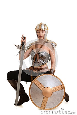 Female warrior kneeling with sword and shield Stock Photo