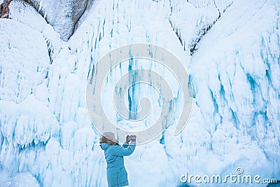 Female wonderer shooting video on smartphone of a big ice rock Stock Photo
