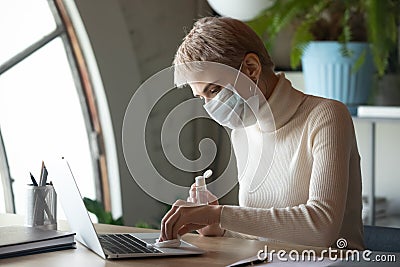 Female worker disinfect office workplace with sanitizer Stock Photo