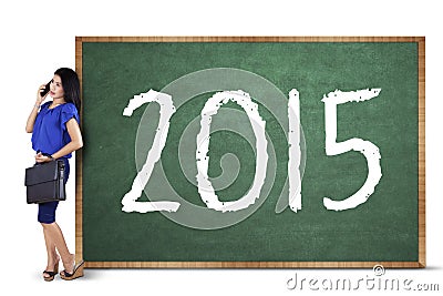 Female worker with numbers 2015 on blackboard Stock Photo