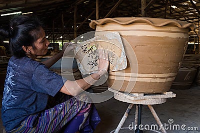 Female worker printing Dragon design with white clay Editorial Stock Photo