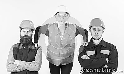 Female worker supported by men in uniform, put hands on male shoulders. Men and woman in helmets with confident faces Stock Photo