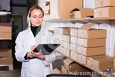 Female worker transporting cart cardboard cases Stock Photo