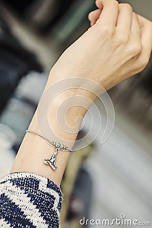 Female wrist wearing tiny jewelry bracelet Stock Photo