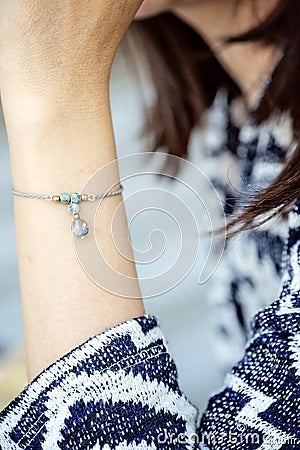 Female wrist wearing tiny jewelry bracelet Stock Photo