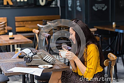 Female writer with vintage typewriter in a coffee shop Stock Photo