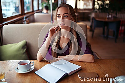 Female writing in notebook in restaurant. Stock Photo