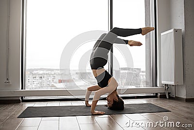 Athletic woman working out yoga in spacious studio Stock Photo