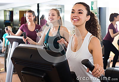 Females training on elliptical trainers in fitness club Stock Photo