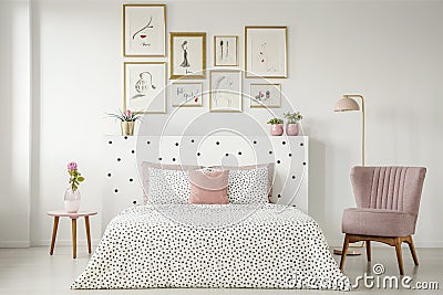 Feminine bedroom interior with a double bed with dotted sheets, Stock Photo