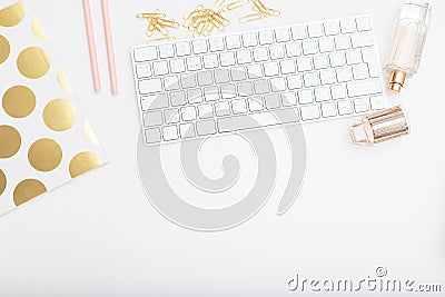 Feminine desk with pink and gold objects on a white background. Stock Photo