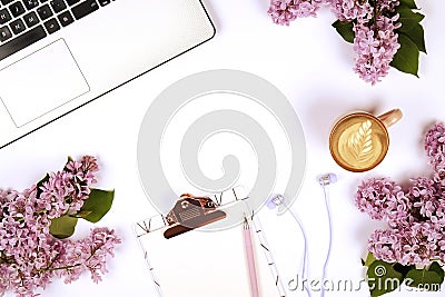 Top view of female worker desktop with laptop, flowers and different office supplies items. Feminine creative design workspace. Stock Photo