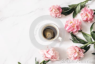 Feminine floral composition. Cup of coffee and pink peonies flowers on white marble table background. Empty space. Flat Stock Photo
